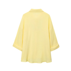 Back view of light yellow cotton linen shirt showing breathable fabric texture and rolled sleeves