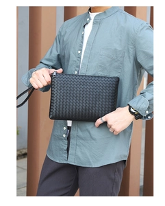 Close-up of black woven leather texture on a men's large capacity business clutch bag