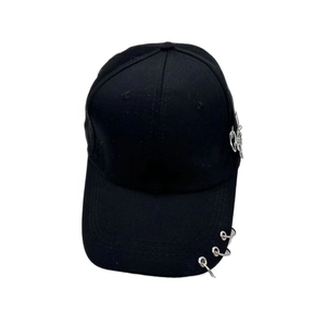 Détail d'une casquette punk noire avec anneaux en métal argenté et décoration de chaîne