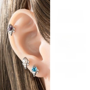 Macro shot of seashell zircon ear studs with purple, blue gems and white pearls