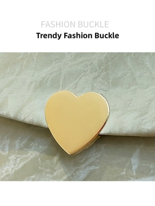Détail de la boucle en forme de cœur dorée sur sacoche à motif marbre beige clair