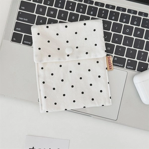 Detailed view of the polka dot canvas mini pouch with snap closure on a laptop keyboard