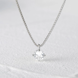 Detailed close-up of a silver box chain with a four-prong set round cubic zirconia stone