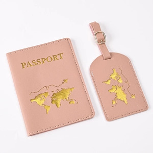 Close-up of pink PU leather passport holder and luggage tag with gold world map stamp