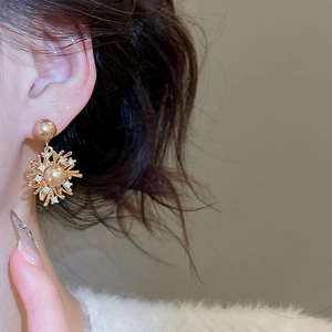 Dettaglio dell'orecchino a fiore placcato oro 18K con perla champagne e zircone