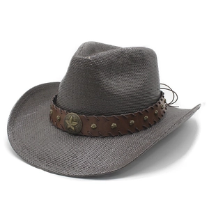 Detail of straw cowboy hat featuring leather band with studs and metal star badge