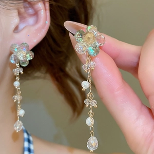 Detailed close-up of crystal flower earrings with dangling freshwater pearl tassels