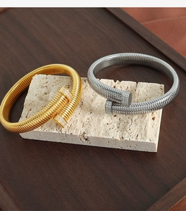 Detail of gold and silver spiral bracelets with sparkling rhinestone caps on stone stand