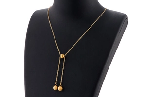 Detail of gold stainless steel Y-shaped necklace with matte bead pendants and slide buckle
