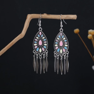 Close-up of Bohemian earrings with pink enamel inlay and hanging silver leaf tassels