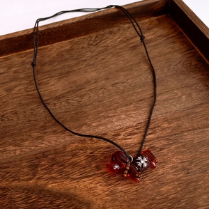 Gros plan d'un pendentif chiot en verre ambré sur un collier en cordon tressé noir