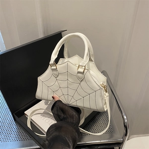 White handbag with black spider web stitching, top handle, and detachable strap