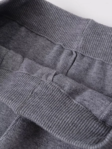 Vue macro d'un tricot côtelé gris foncé montrant les coutures de ce pantalon large