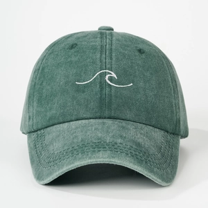 Detailed close-up of embroidered white wave pattern on washed cotton baseball cap fabric