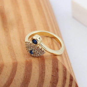 Detailed view of evil eye ring with gold plating, white zircons and blue stones