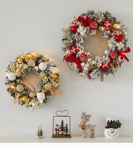 Detail of Christmas wreaths with LED lights and snow flocking on a home wall