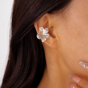 Detailed close-up of a silver floral ear cuff showing the smooth metallic finish and petals