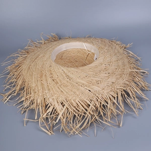 Détail d'un chapeau de soleil en raphia bohème avec bords effilochés et large bord beige