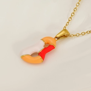 Detail of colorful drip glaze pendant with gold finish on an elegant link chain