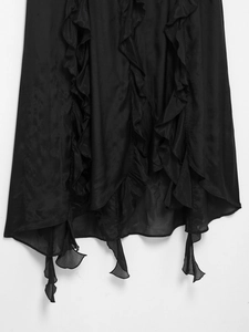 Detail of black ruffled hemline with translucent fabric layers on romantic maxi dress