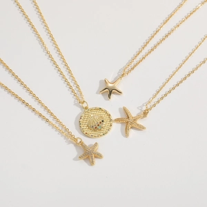 Four elegant gold starfish pendants with zircon and shell charms on delicate chains