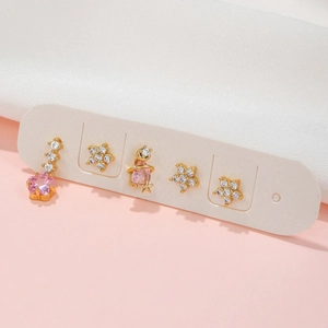Detailed set of 5 gold earrings featuring pink zircons, flowers, and a star planet theme