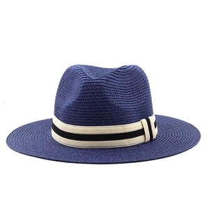 Detail of navy straw Panama hat featuring a textured weave and striped grosgrain band