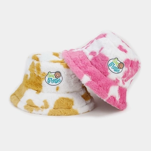 Cute plush cow print bucket hat with Sea Breeze patch in pink and yellow colors