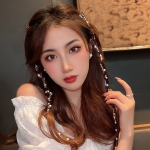 Close-up of hair braid chain with elegant pearls and sparkling rhinestones for women