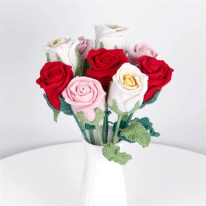 Handmade crochet rose bouquet with red, pink and white flowers in a white ceramic vase