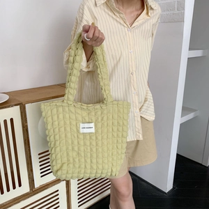 Dettaglio della borsa tote verde chiaro con trama trapuntata a bolle e spalline lunghe