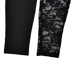 Detailed close-up of asymmetrical hem featuring solid black fabric and floral lace mesh