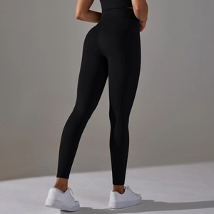 Detail view of high waisted black yoga pants showing the peach lift and tight knit texture