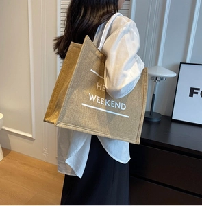 Detailed texture of large linen tote bag with HE WEEKEND print in a minimalist room