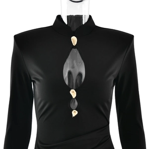 Détail d'une robe noire ajustée avec découpe en goutte et boutons dorés élégants