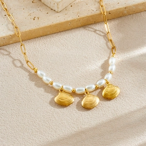 Collier doré avec pendentifs coquillages et perles blanches sur chaîne élégante