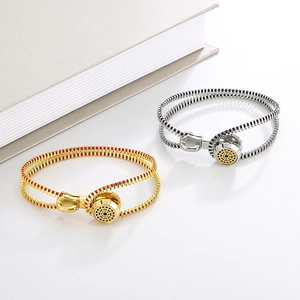 Creative zipper-style titanium steel bracelets in gold and silver on a book background