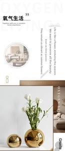 Detail of two spherical gold electroplated ceramic vases with white roses for home decor