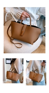 Detailed macro view of brown lychee grain leather texture and gold buckle on tote bag