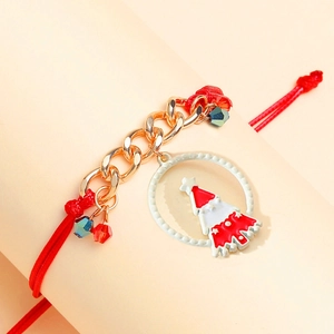Close-up of a red woven Christmas tree bracelet with gold chain and enamel pendant