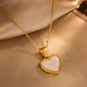 Elegant gold-plated heart pendant necklace with white marble inlay on silk background