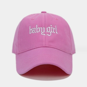 Dettaglio del cappellino rosa in cotone con ricamo bianco baby girl in stile gotico