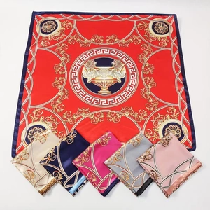 Flat lay of satin silk scarves showing Greek key patterns in red, blue and pink