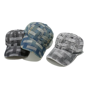 Close-up of distressed denim baseball caps with woven checkered texture and frayed edges