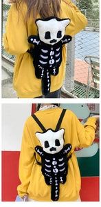 Detalle de la mochila de peluche blanca y negra con diseño de calavera y textura suave