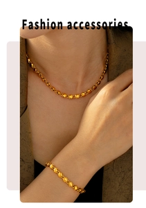 Vista dettagliata di un set elegante collana e bracciale a sfere dorate su modella
