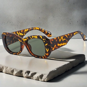 Macro shot of retro square tortoiseshell sunglasses on a minimalist stone surface