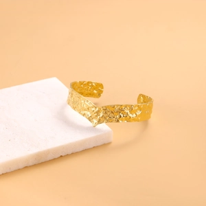 Gold open cuff bracelet with hammered texture and V-shaped minimalist design for women