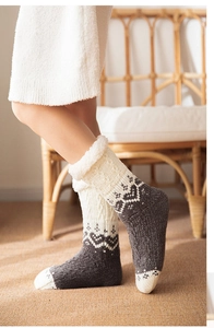Detail of knit winter socks with Nordic patterns and plush white faux fur cuff trim