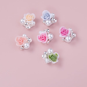 Detail of 3D rose and pearl nail art charms in six vibrant colors on pink background